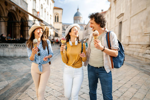 istock Three smiling tourists eating ice cream while exploring the city 1493596330