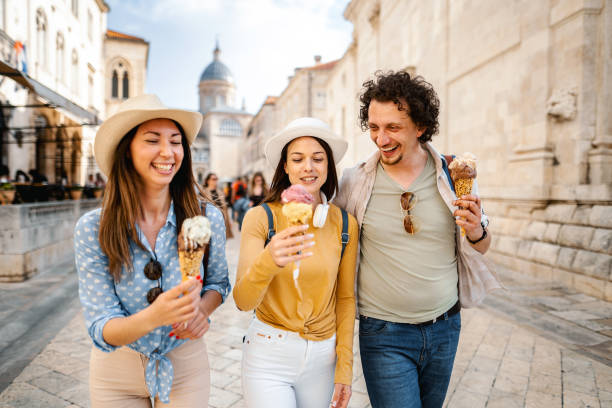 istock Three smiling tourists eating ice cream while exploring the city 1493596390
