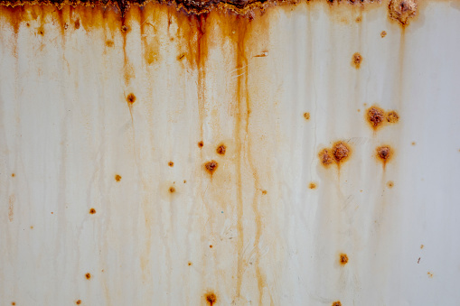 Old peeling paint on rusted iron surface with corrosion spots