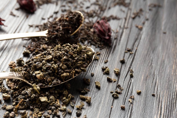 istock Dry green and black tea on a dark background close-up. 1493599354