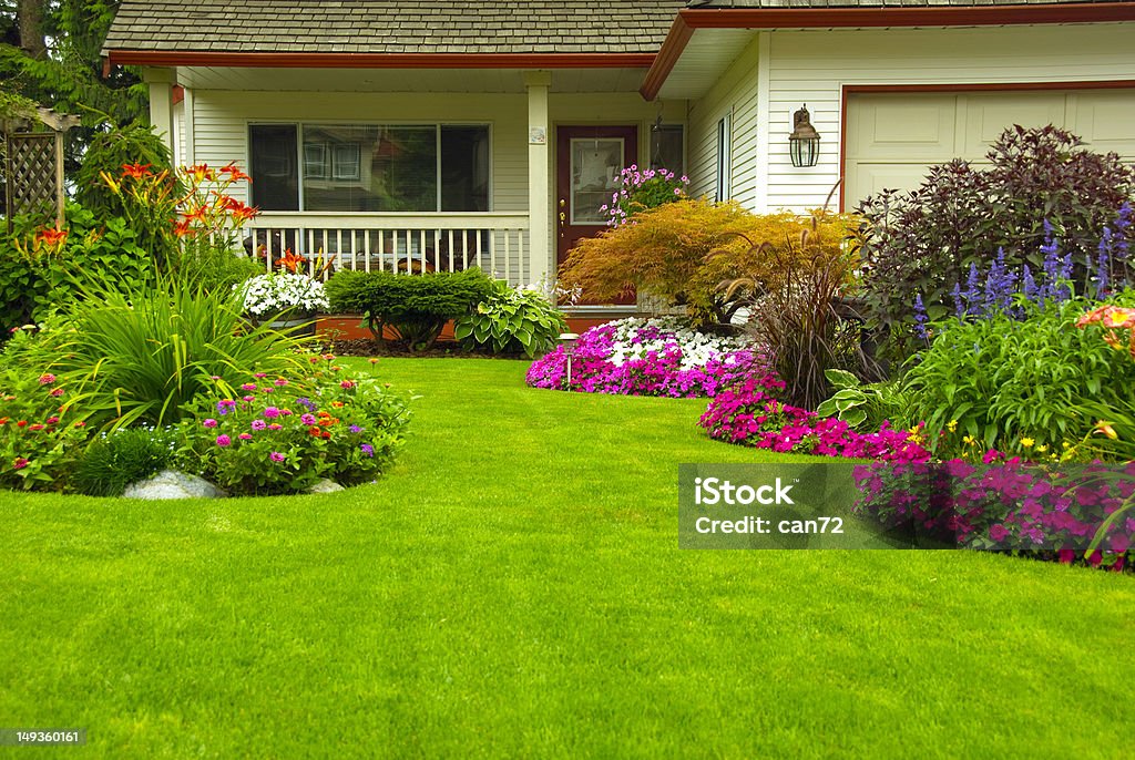 Manicured House and Garden Manicured House and Garden displaying annual and perennial gardens in full bloom. Yard - Grounds Stock Photo