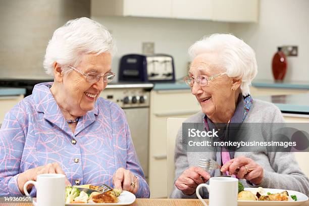 Two Gray Haired Friends Enjoying A Meal Together Stock Photo - Download Image Now - Senior Adult, Eating, 80-89 Years