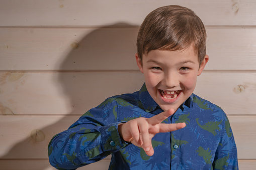 Studio shot of a cute little boy  giving you the ok sign against a white background
