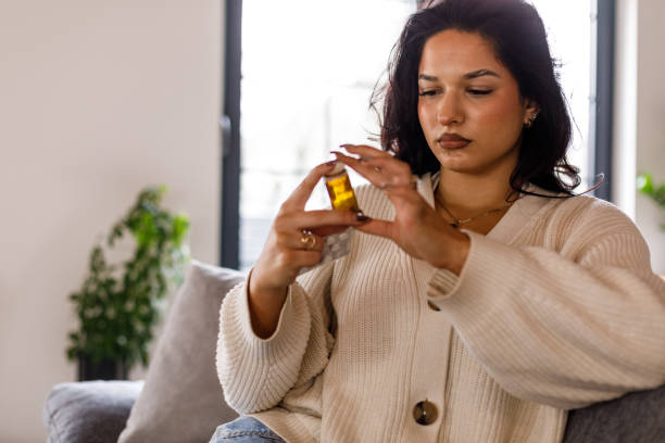 istock Young woman reading labels on the pill bottle and packets when taking her new medication 1493625383