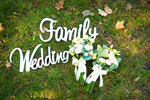 the word marriage and the family from a tree on a green grass and bridal bouquet