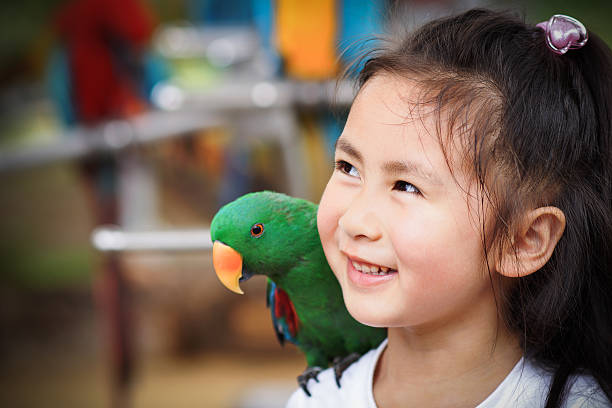 istock cute little girl and parrot 149362657