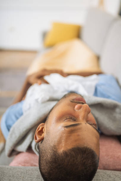 istock Young man with the flu, asleep with his used tissues 1493631677