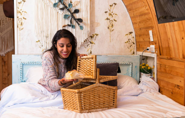 Delightful Surprise: Latina Woman Unveiling Breakfast in a Country Bed Latina woman sits on a cozy bed in a charming country house, her face displaying a delightful expression of surprise unusual basket stock pictures, royalty-free photos & images