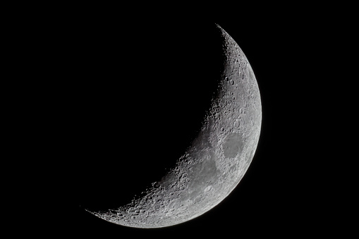 Stock photo showing a full moon shining against a black, night time, starless sky.