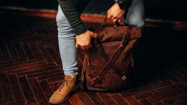 istock man's hand holding a canvas backpack. Model wears a brown belt bag, Medium Leather Backpack Man Rolltop Leather Rucksack Bag 1493644525