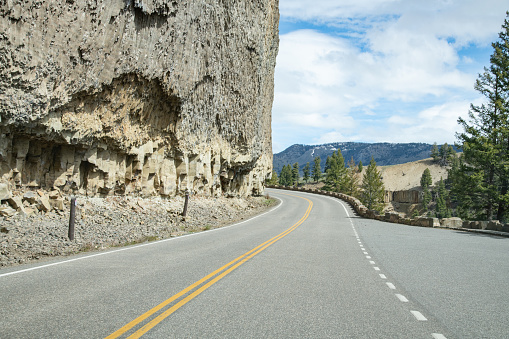 Highway through rocks in the Yellowstone Ecosystem in western USA, Nearest cities are Gardiner, Cooke City, Bozeman, Billings, Montana, Jackson, Wyoming, Salt Lake City, Utah and Denver, Colorado.