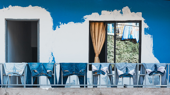 Different kinds of blue jeans drying on the balcony