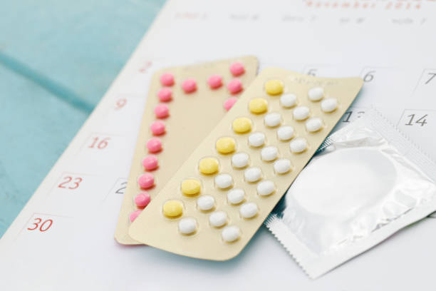 contraceptive control pills and condom on date of calendar background  calculate date control the birth rate. health care and medicine, contraception concept. empty space for text. - sex education condom contraceptive sex imagens e fotografias de stock