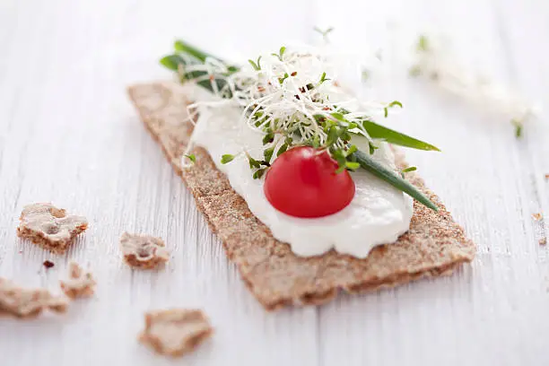 crisp bread sandwich with cream cheese, broccoli sprouts, tomato and chive