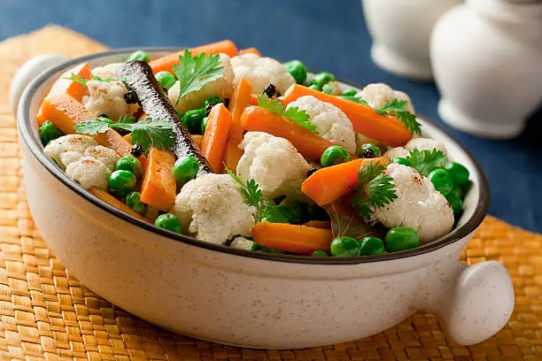 cauliflower, carrots and green peas steamed and sauteed  in olive oil with cinnamon, bay leaf and peppercorns.