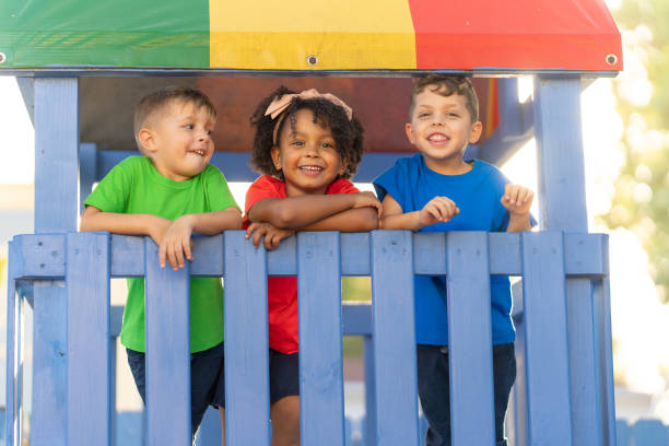 istock Three preschool children are happily playing and exploring on top of a playground structure, filled with excitement and wonder 1493661118