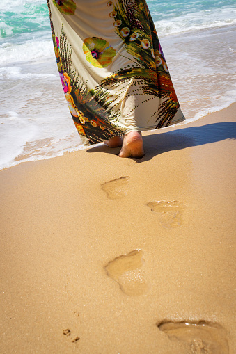human footprints on the hot golden sea sand , a delightful walk on the beach