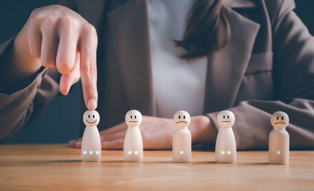 istock Customer services best excellent business rating experience. Satisfaction survey concept.  Business woman chooses a smiley face on wood doll. 3 Star Satisfaction. or HR chooses the person in the team. 1493664805