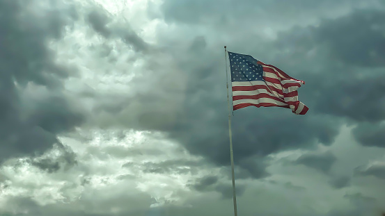 Picture of the American flag as it is being whipped around on a overcast and windy day in Alaska