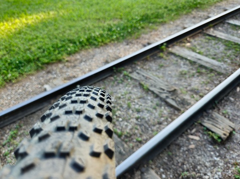 Close-Up Of Bike Tire Rolling Over Miniature Train Railroad Track