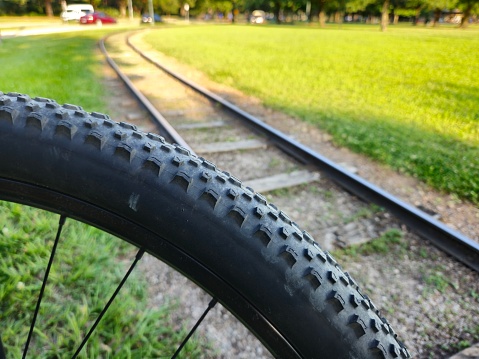 Close-Up Side View Of Bike Tire And Miniature Train Railroad Track