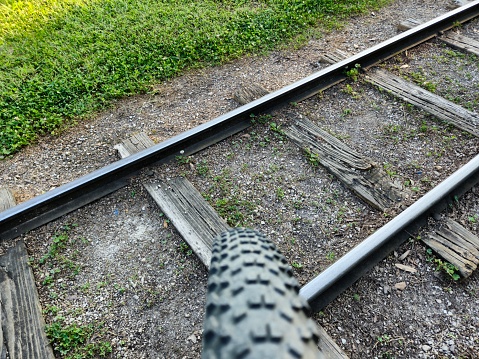 Bike Tire Rolling Over Miniature Train Railroad Track