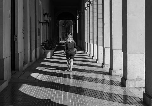 Rear view woman walking at arcade in city, Palma - Majorca