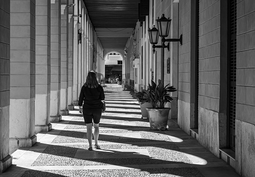Rear view woman walking at arcade in city, Palma - Majorca