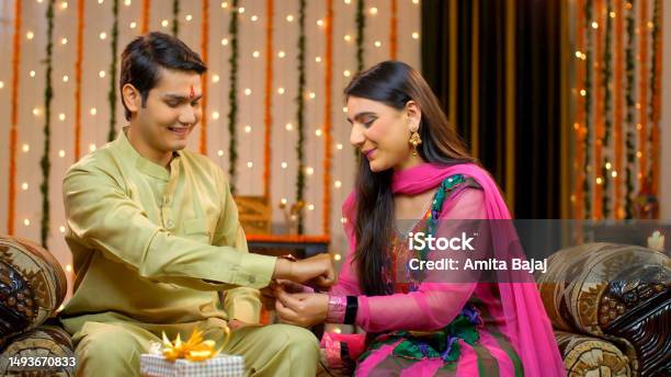 Young Smiling Brother And Sister Celebrating Raksha Bandhan Together Tying Rakhi Indian Model Stock Photo - Download Image Now