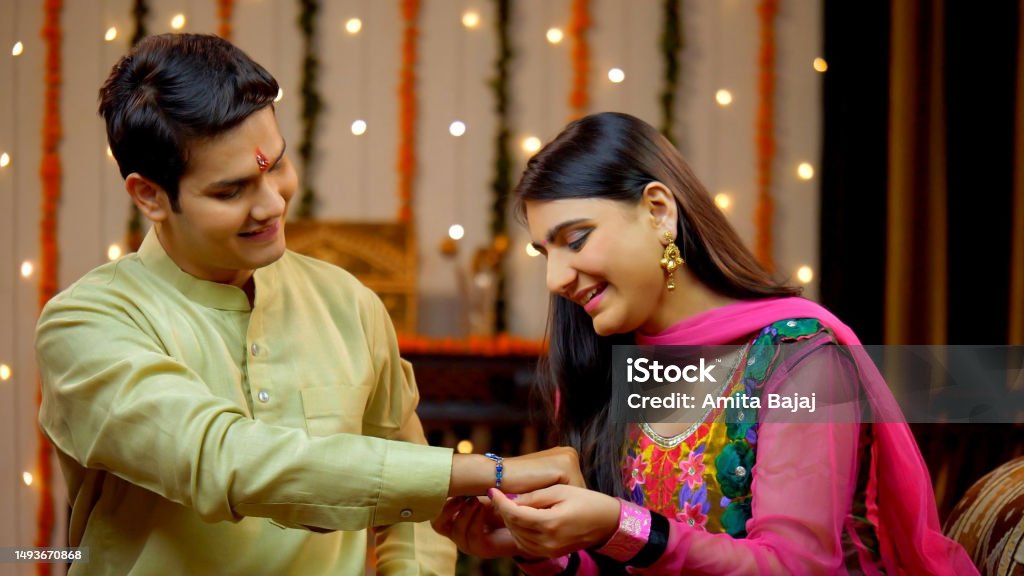 Indian sister tying rakhi on her brother's wrist and expressing the love - Raksha Bandhan, Indian Model Loving sister ties a sacred thread embellished with her love and affection towards the brother - Rakhi concept 20-24 Years Stock Photo