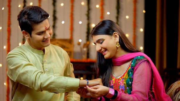 Indian sister tying rakhi on her brother's wrist and expressing the love - Raksha Bandhan, Indian Model Loving sister ties a sacred thread embellished with her love and affection towards the brother - Rakhi concept rakhi stock pictures, royalty-free photos & images