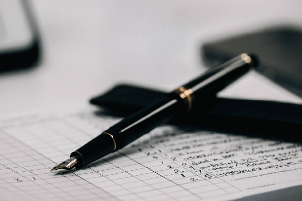 A sleek, black fountain pen delicately rests upon the pages of a flight journal, waiting to capture the pilot's thoughts and experiences during their airborne adventures.