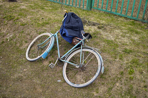 an old bicycle and a jacket abandoned on the ground, outdoor shot