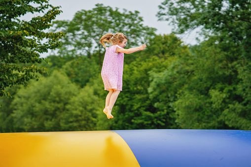 Shot of an adorable little boy and girl jumping on a trampoline in the backyard at home