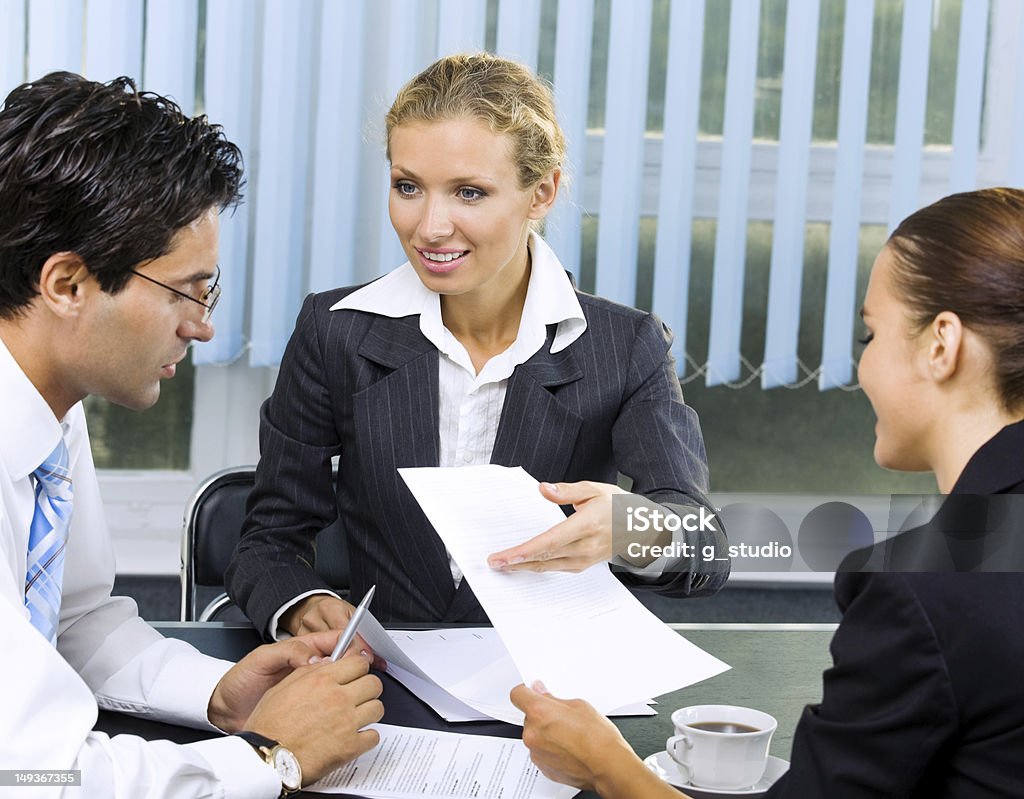 Businesspeople working with document at office Three happy smiling business people working with document at office Adult Stock Photo