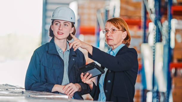 istock Businesswoman manager discuss with warehouse worker  in a distribution warehouse 1493676762