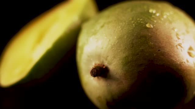 Mango fruit rotating on black background.View of whole mango fruits rotate