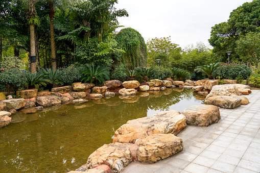 wide stone pond in park garden
