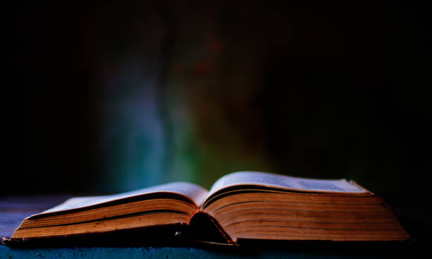 istock an ancient book open on an old table in the attic 1493689147