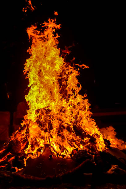 istock Fire flames on black background, Blaze fire flame texture background, Beautifully, the fire is burning, Fire flames with wood and cow dung bonfire 1493689186