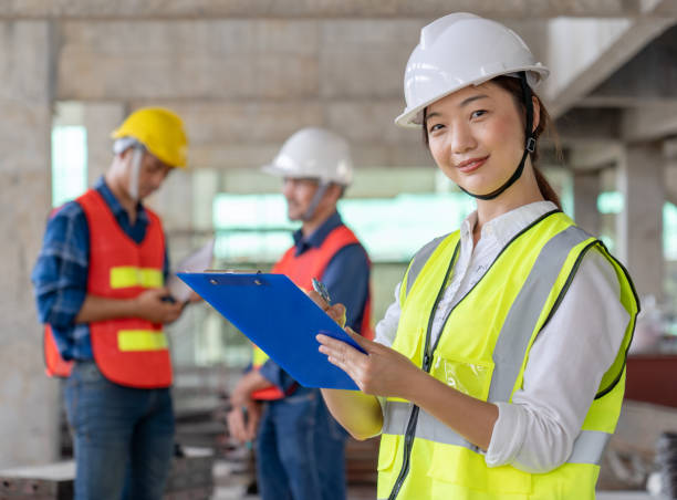 istock smart Asian woman civil technician engineer together with workers inspect infrastructure construction progress 1493693294