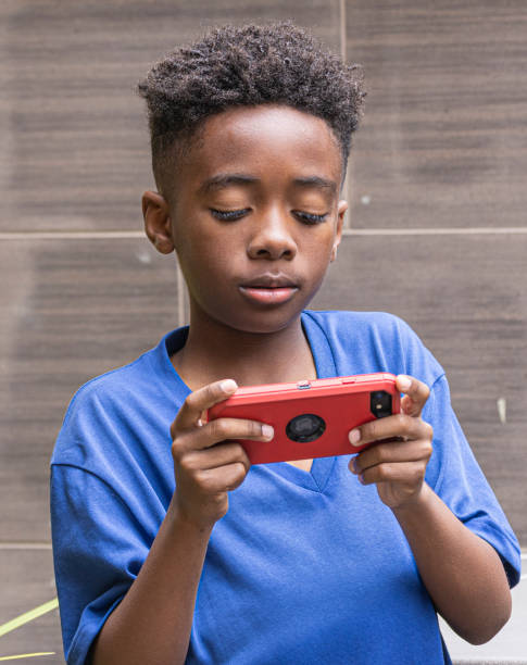 istock African-American boy plays on his cell phone. 1493694483