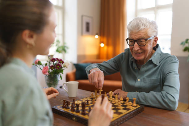 istock Senior man playing chess with his granddaughter. 1493694518