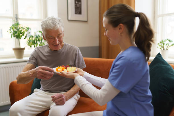 istock Young nurse prepared fruit snack for senior man. 1493694773