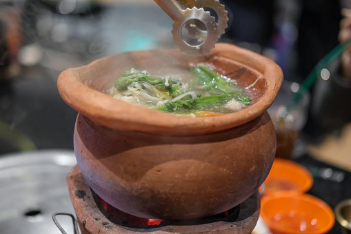 Jim Joom, Thai style of hot pot from the Northeast of Thailand contains pork, vegetable and glass noodle in clay bowl