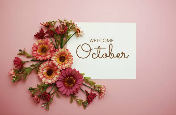 istock Welcome October typography text with flowers on pink background 1493697536