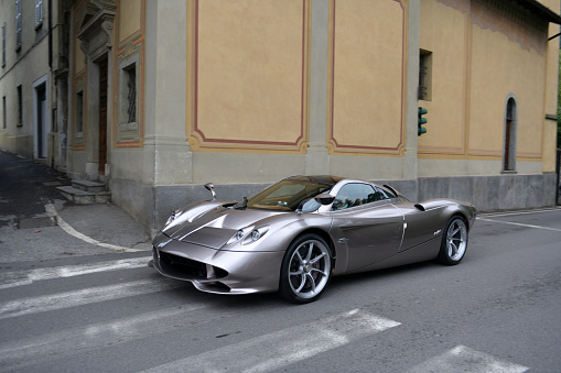 Cernobbio, Como - May 21, 2023: Concorso d'Eleganza Villa d'Este 2023\nA seven million vehicle number 2 of 5 units a Pagani Huayra Codalunga (2022) drives through the streets of Cernobbio.\n\nIn Europe, the Concorso d'Eleganza Villa d'Este has developed into a meeting point for lovers of high-quality classic automobiles.\nActive automotive designers are also looking for inspiration for their work there.\nIn addition, the event is given a special touch by the Villa d'Este, a former cardinal's palace with park, located directly on the lake\na neat setting and a social touch.\nOn Sunday, vehicles for the general public will be shown on the grounds of the neighboring Villa Erba.\nThe vehicles drive early in the morning from Villa d'Este to Villa Erba through the small town of Cernobbio\nat Como\non the public road, on Via Regina\n\nIn the background you can see the church Chiesa di Maria delle Grazie.\n\n\n\nThe event traditionally takes place on the third weekend in May each year.\n\nA jury decides on the two prizes \