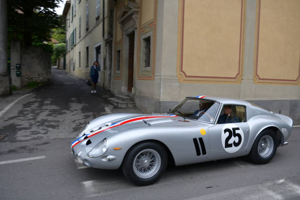 The Concorso Cernobbio, Como - May 21, 2023: Concorso d'Eleganza Villa d'Este 2023.
The Ferrari 250 GTO is a GT car produced by Ferrari from 1962 to 1964 for homologation into the FIA's Group 3 Grand Touring Car category. It was powered by Ferrari's Tipo 168/62 Colombo V12 engine. 

In Europe, the Concorso d'Eleganza Villa d'Este has developed into a meeting point for lovers of high-quality classic automobiles.
Active automotive designers are also looking for inspiration for their work there.
In addition, the event is given a special touch by the Villa d'Este, a former cardinal's palace with park, located directly on the lake
a neat setting and a social touch.
On Sunday, vehicles for the general public will be shown on the grounds of the neighboring Villa Erba.
The vehicles drive early in the morning from Villa d'Este to Villa Erba through the small town of Cernobbio
at Como
on the public road, on Via Regina

In the background you can see the church Chiesa di Maria delle Grazie.



The event traditionally takes place on the third weekend in May each year.

A jury decides on the two prizes "Best of Show" and the audience awards the "Coppa d'Oro Villa d'Este" as a further prize.
Assuming perfect condition, the criteria are beauty, rarity and emotionality.
Vehicles that have already received awards in previous years cannot be awarded again.
Since 2002, contemporary prototypes or concept vehicles have also been awarded. concorso stock pictures, royalty-free photos & images