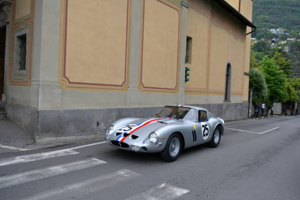 The Concorso Cernobbio, Como - May 21, 2023: Concorso d'Eleganza Villa d'Este 2023.
The Ferrari 250 GTO is a GT car produced by Ferrari from 1962 to 1964 for homologation into the FIA's Group 3 Grand Touring Car category. It was powered by Ferrari's Tipo 168/62 Colombo V12 engine. 

In Europe, the Concorso d'Eleganza Villa d'Este has developed into a meeting point for lovers of high-quality classic automobiles.
Active automotive designers are also looking for inspiration for their work there.
In addition, the event is given a special touch by the Villa d'Este, a former cardinal's palace with park, located directly on the lake
a neat setting and a social touch.
On Sunday, vehicles for the general public will be shown on the grounds of the neighboring Villa Erba.
The vehicles drive early in the morning from Villa d'Este to Villa Erba through the small town of Cernobbio
at Como
on the public road, on Via Regina

In the background you can see the church Chiesa di Maria delle Grazie.



The event traditionally takes place on the third weekend in May each year.

A jury decides on the two prizes "Best of Show" and the audience awards the "Coppa d'Oro Villa d'Este" as a further prize.
Assuming perfect condition, the criteria are beauty, rarity and emotionality.
Vehicles that have already received awards in previous years cannot be awarded again.
Since 2002, contemporary prototypes or concept vehicles have also been awarded. concorso stock pictures, royalty-free photos & images