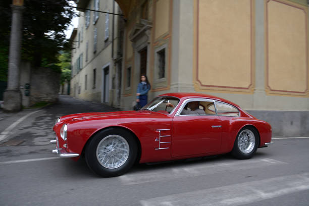 The Concorso Cernobbio, Como - May 21, 2023: Concorso d'Eleganza Villa d'Este 2023.
Maserati A6G/54 was the internal designation for a road sports car that the Italian car manufacturer Maserati produced from 1954 to 1957
 produced. The car was also officially marketed as the Maserati 2000 GT, just like its predecessor (internal: A6G).
Technically, the A6G/54 was the road version of the A6GCS racing car, with which it was closely related.
The A6G/54 was available with open and closed bodies from Allemano, Frua and Zagato. A total of around 60 vehicles were built. The history of each car is unusually well documented.
The cars are among the exclusive classics that now reach prices in the millions at auction.

In Europe, the Concorso d'Eleganza Villa d'Este has developed into a meeting point for lovers of high-quality classic automobiles.
Active automotive designers are also looking for inspiration for their work there.
In addition, the event is given a special touch by the Villa d'Este, a former cardinal's palace with park, located directly on the lake
a neat setting and a social touch.
On Sunday, vehicles for the general public will be shown on the grounds of the neighboring Villa Erba.
The vehicles drive early in the morning from Villa d'Este to Villa Erba through the small town of Cernobbio
at Como
on the public road, on Via Regina

In the background you can see the church Chiesa di Maria delle Grazie.

The event traditionally takes place on the third weekend in May each year.

A jury decides on the two prizes "Best of Show" and the audience awards the "Coppa d'Oro Villa d'Este" as a further prize.
Assuming perfect condition, the criteria are beauty, rarity and emotionality.
Vehicles that have already received awards in previous years cannot be awarded again.
Since 2002, contemporary prototypes or concept vehicles have also been awarded. concorso stock pictures, royalty-free photos & images